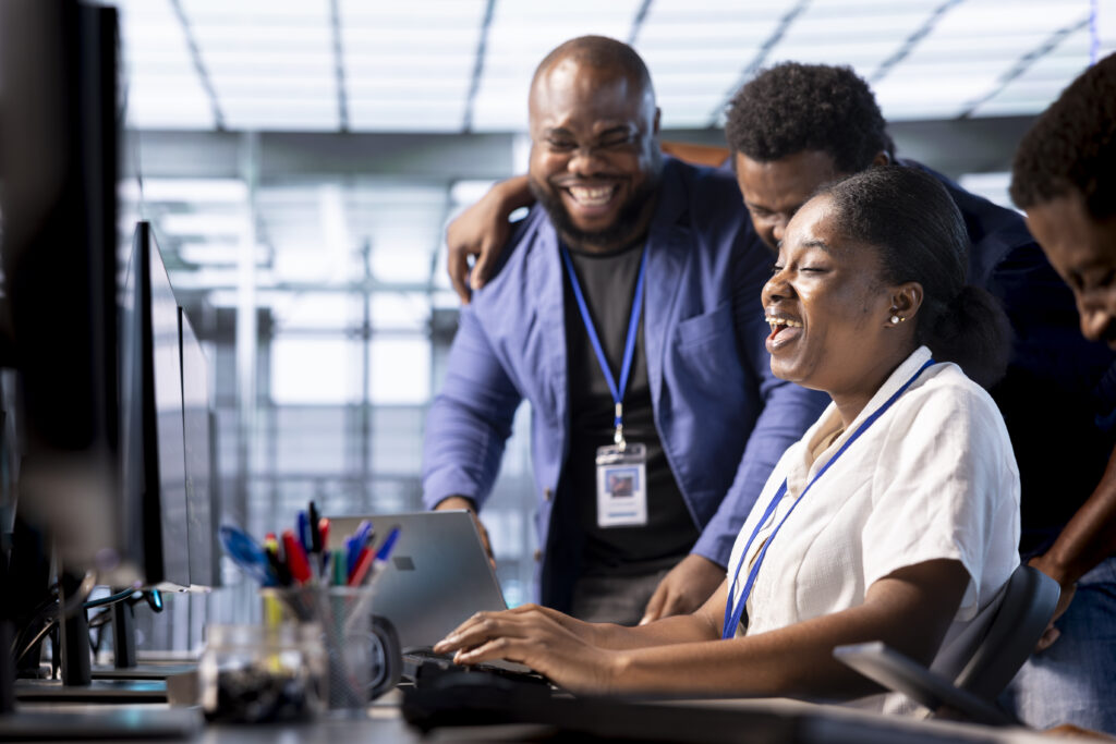 Team of happy engineers laughing, enjoying each other company while working in server farm workplace. Jolly coworkers having fun together during job break in data center office